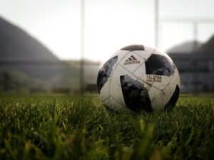 Soccer ball on grass at dusk with blurred background