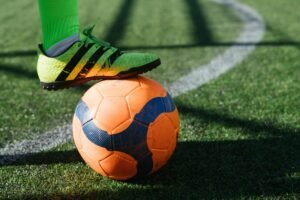 A player resting a foot on a football before kickoff